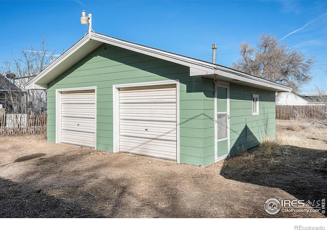 detached garage featuring fence