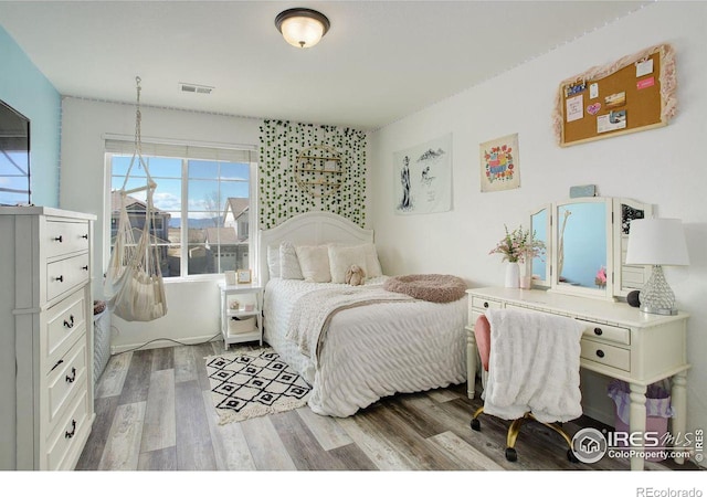 bedroom with visible vents and wood finished floors