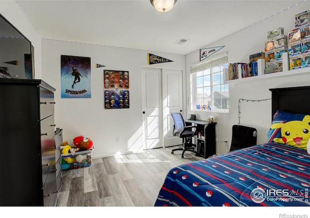 bedroom featuring wood finished floors and visible vents