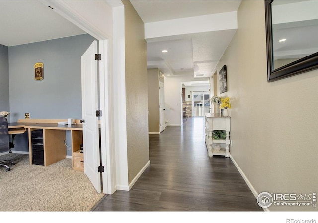 corridor with dark wood-type flooring and baseboards