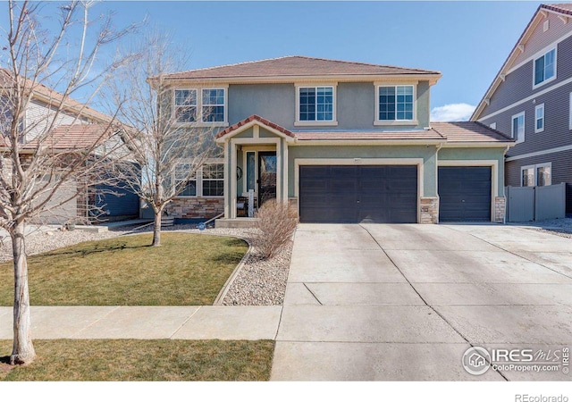 3431 Sandalwood Ln, Johnstown, CO 80534 - traditional-style house featuring driveway, stone siding, a tile roof, stucco siding, and a front yard