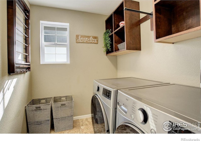 laundry area with cabinet space, baseboards, and independent washer and dryer