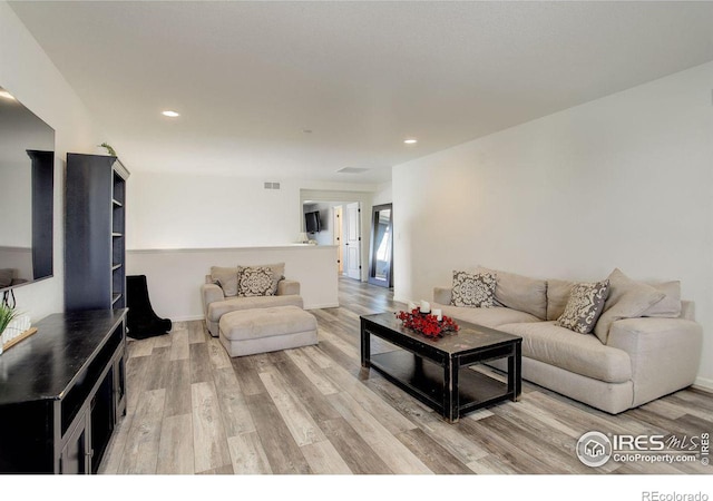 living room featuring light wood finished floors and recessed lighting