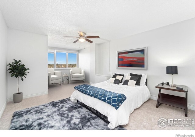 carpeted bedroom featuring a ceiling fan, baseboards, and a textured ceiling