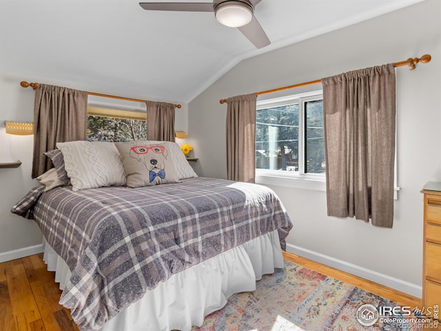 bedroom with ceiling fan, baseboards, vaulted ceiling, and wood finished floors