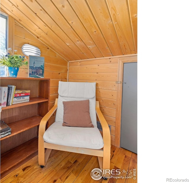 sitting room with wooden ceiling, wood walls, vaulted ceiling, and wood finished floors