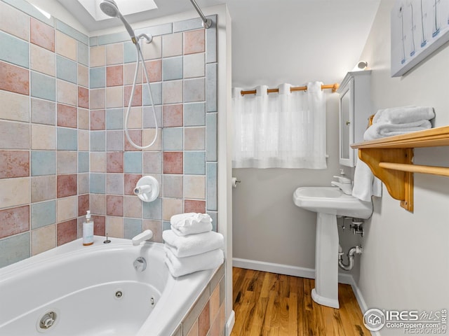 full bathroom featuring baseboards and wood finished floors