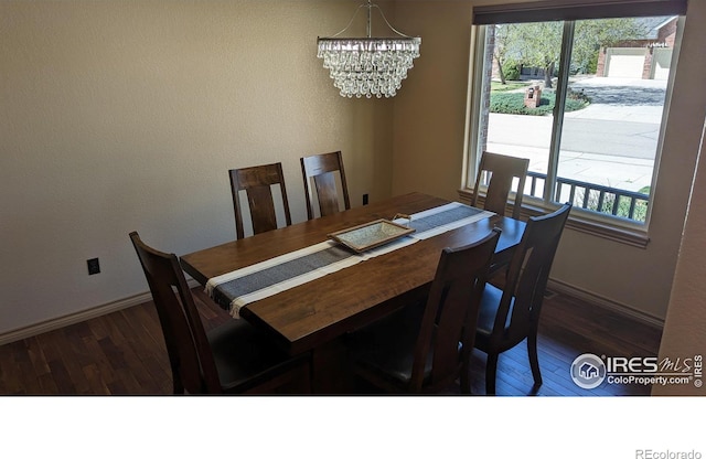 dining area featuring wood-type flooring, baseboards, and a notable chandelier