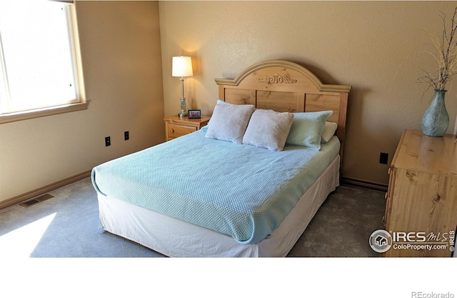 carpeted bedroom featuring visible vents and baseboards