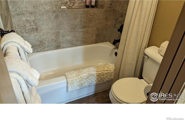 bathroom featuring a textured wall and toilet