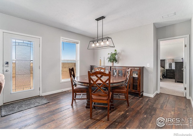 dining area featuring dark wood-style floors, visible vents, and baseboards