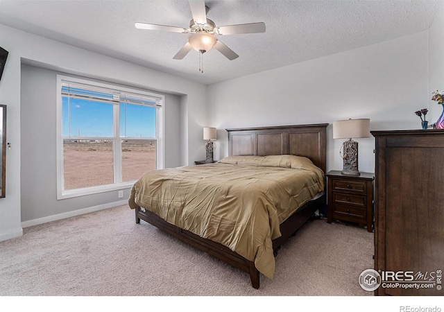 bedroom featuring a textured ceiling, baseboards, and light colored carpet