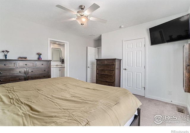 bedroom featuring baseboards, visible vents, connected bathroom, light colored carpet, and a sink