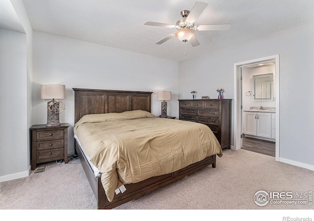 bedroom featuring light carpet, a ceiling fan, baseboards, and connected bathroom