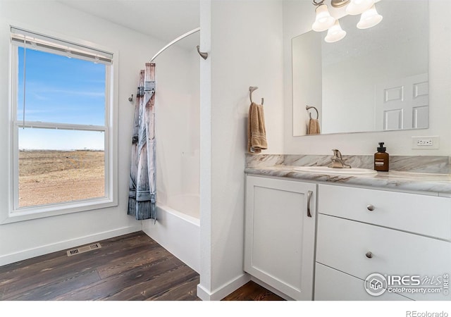 bathroom featuring shower / tub combo with curtain, visible vents, vanity, wood finished floors, and baseboards