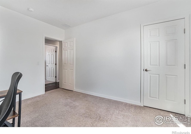 carpeted home office featuring baseboards