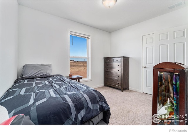 bedroom with light carpet, visible vents, and baseboards