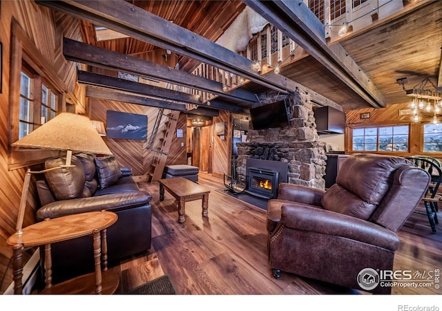 living area with beam ceiling, wood walls, wood finished floors, and wood ceiling