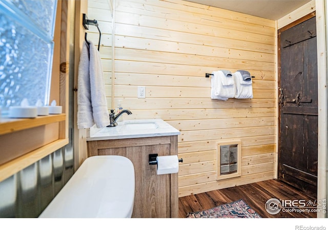 bathroom featuring wooden walls, visible vents, wood finished floors, and vanity