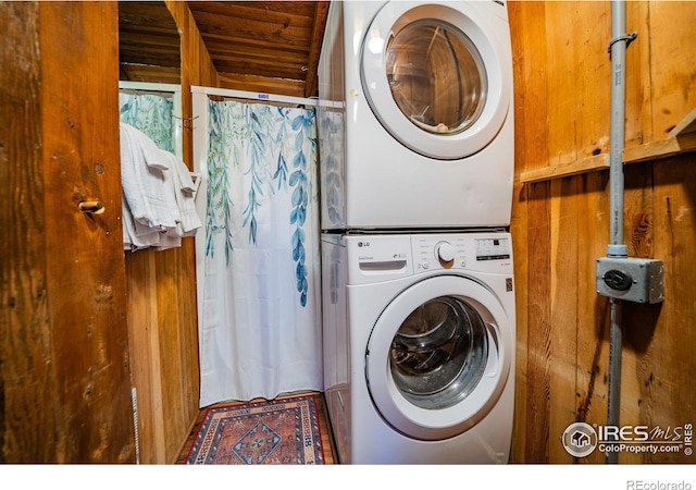 washroom featuring stacked washer / drying machine and laundry area