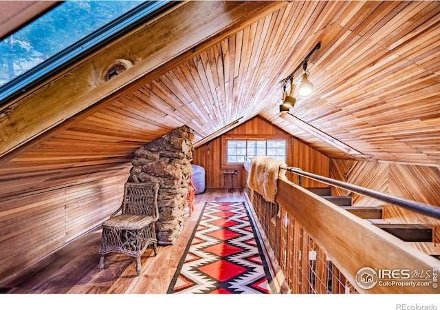 unfurnished bedroom featuring vaulted ceiling, wood ceiling, wood walls, and wood finished floors