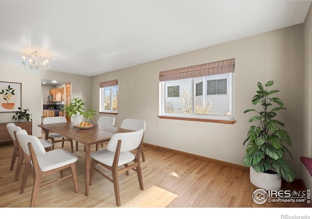 dining room featuring a notable chandelier, light wood-style flooring, and baseboards