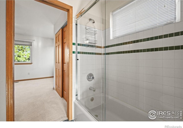 full bath with baseboards and bath / shower combo with glass door