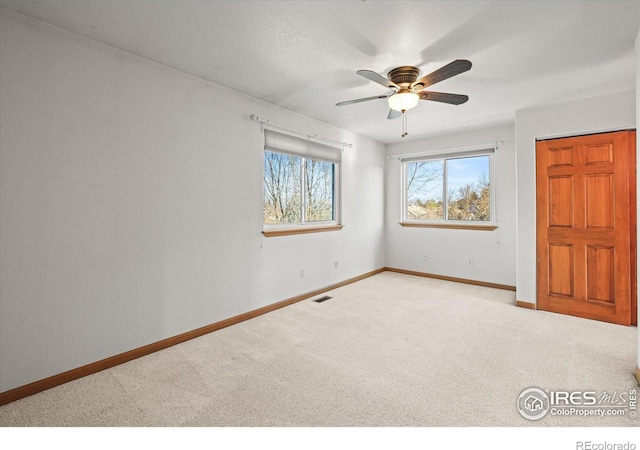 unfurnished bedroom with a ceiling fan, visible vents, baseboards, and carpet flooring