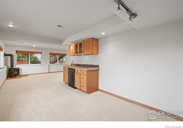 kitchen with visible vents, baseboards, light colored carpet, glass insert cabinets, and a wood stove