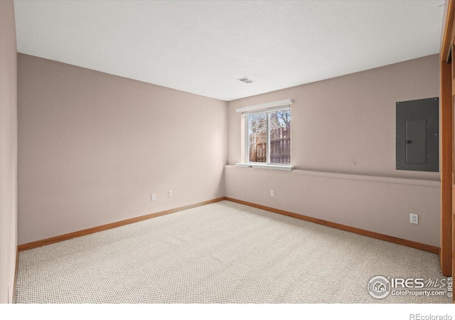 unfurnished room with baseboards, electric panel, visible vents, and carpet flooring