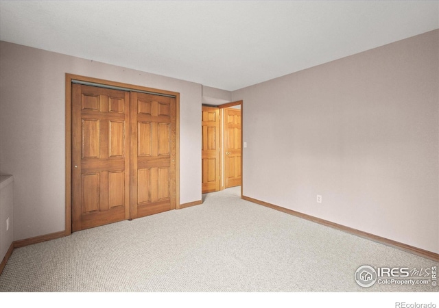 unfurnished bedroom featuring a closet, baseboards, and carpet flooring