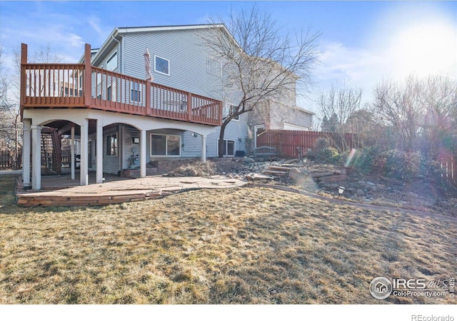 back of house with a deck, a yard, fence, and stairway