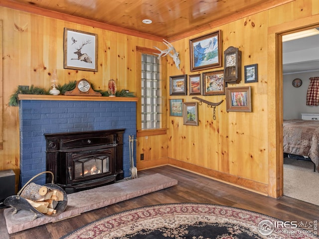 sitting room featuring wood ceiling, a fireplace, wooden walls, and wood finished floors