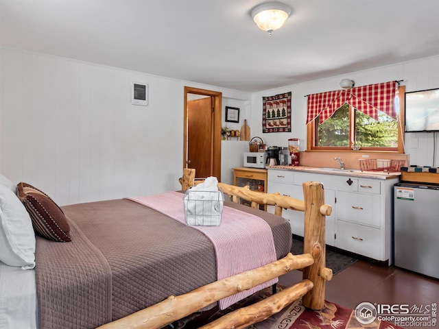 bedroom featuring visible vents, a sink, and freestanding refrigerator