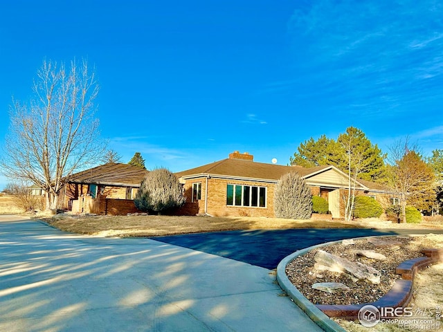 single story home featuring driveway and brick siding