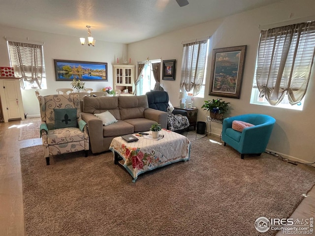 living room featuring a notable chandelier and baseboards