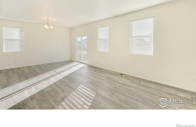 1431 Vantage Pkwy, Berthoud, CO 80513 - empty room featuring wood finished floors, a chandelier, and baseboards
