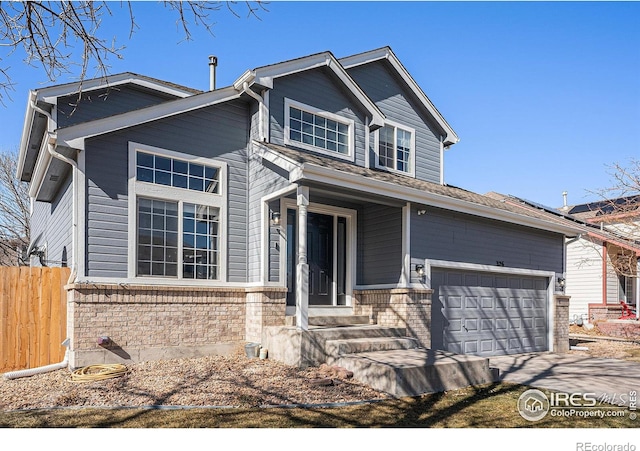 traditional-style home featuring a garage, driveway, brick siding, and fence