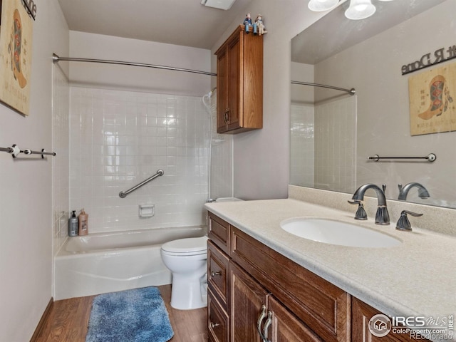 full bath with toilet, shower / bath combination, wood finished floors, and vanity