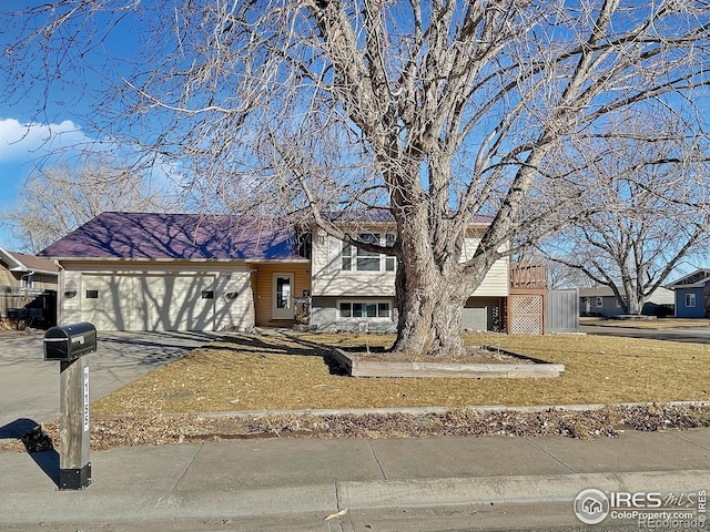 tri-level home with a garage and aphalt driveway