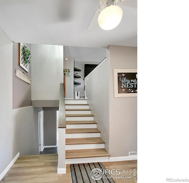 stairway featuring wood finished floors and baseboards