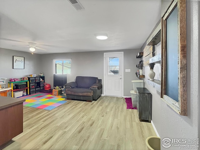 playroom featuring light wood finished floors, plenty of natural light, visible vents, and baseboards