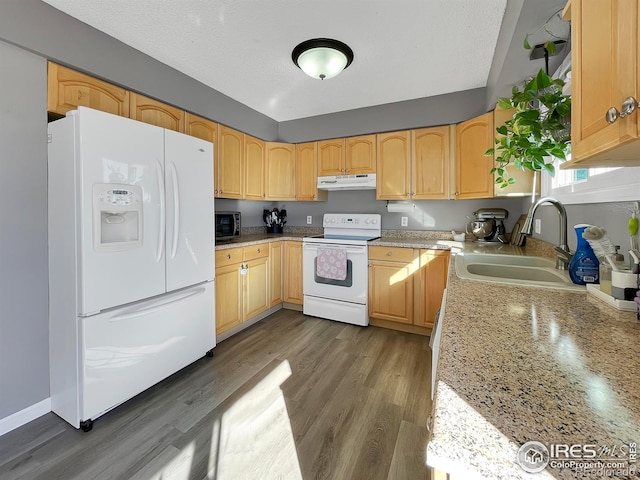 kitchen with white appliances, dark wood-style flooring, a textured ceiling, under cabinet range hood, and a sink