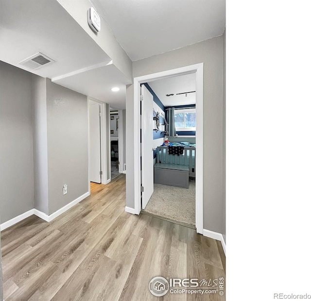 interior space with visible vents, baseboards, and wood finished floors