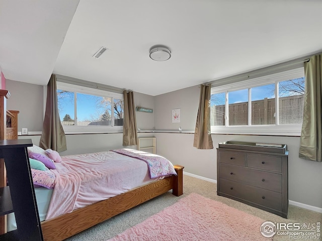 bedroom featuring carpet, baseboards, multiple windows, and visible vents