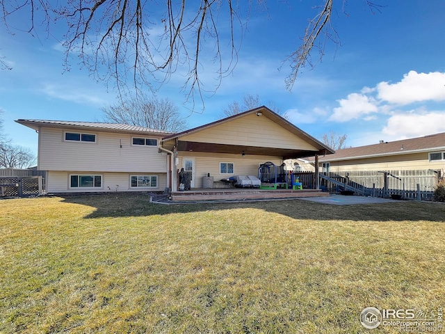 rear view of property featuring a patio area, fence, and a lawn