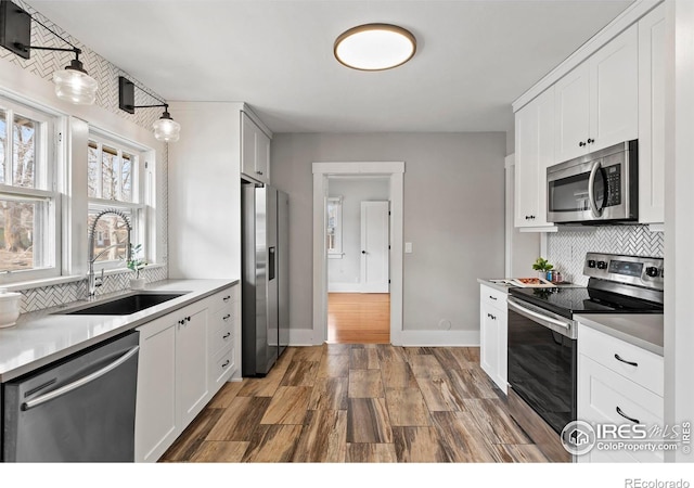 530 Laporte Ave, Fort Collins, CO 80521 - kitchen with tasteful backsplash, a sink, appliances with stainless steel finishes, dark wood finished floors, and white cabinetry