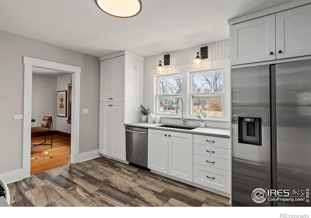 530 Laporte Ave, Fort Collins, CO 80521 - kitchen with baseboards, a sink, light countertops, dark wood finished floors, and stainless steel appliances