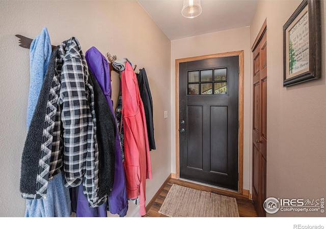 foyer entrance with wood finished floors and baseboards