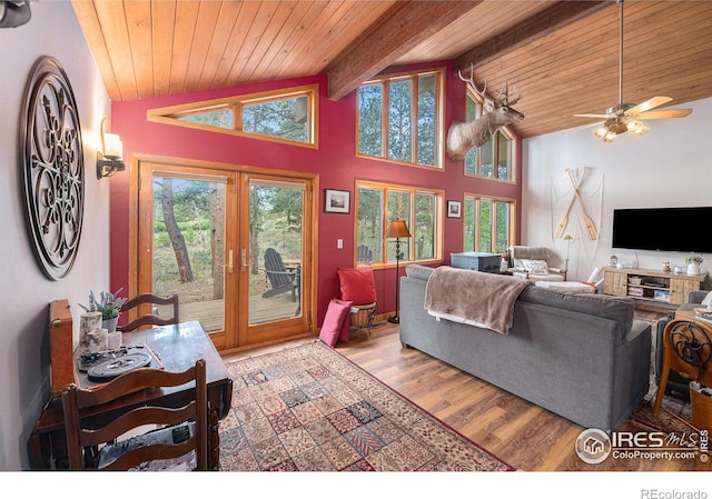 living area featuring vaulted ceiling with beams, french doors, and a wealth of natural light